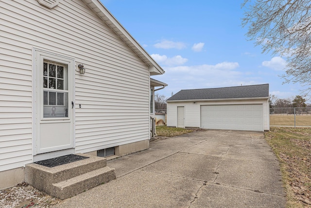 view of side of property featuring an outbuilding, a detached garage, fence, and entry steps