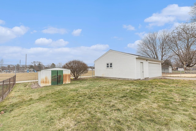 view of yard featuring an outbuilding, fence, and a storage unit