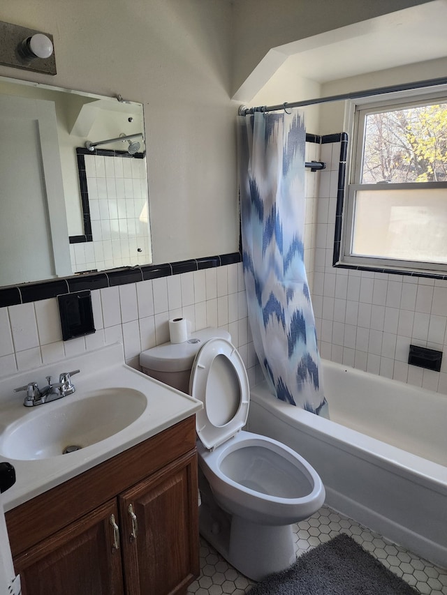 bathroom with shower / tub combo, toilet, tile patterned flooring, vanity, and tile walls