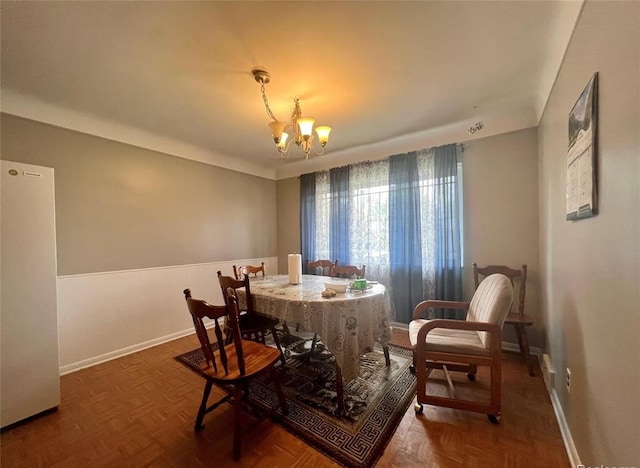 dining area featuring baseboards and a notable chandelier