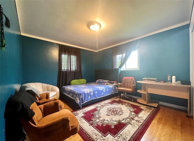 bedroom featuring crown molding and wood finished floors