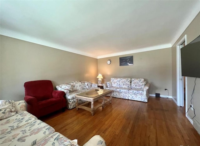 living area featuring baseboards and wood finished floors