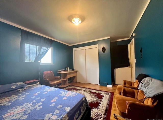 bedroom with crown molding, a closet, and wood finished floors
