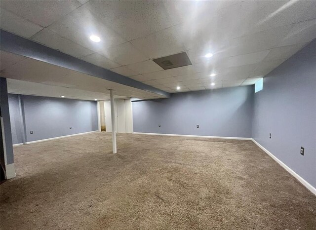finished basement featuring a paneled ceiling, baseboards, carpet flooring, and recessed lighting