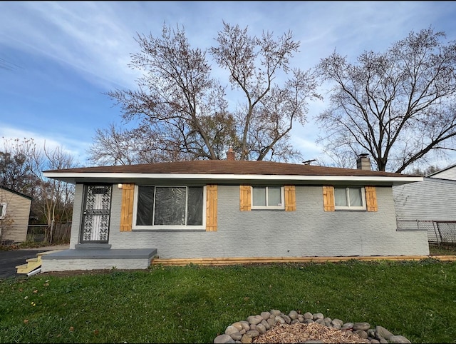 exterior space featuring a chimney, fence, and a yard