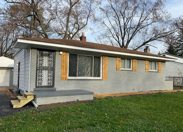 view of front of property featuring an outbuilding, a front lawn, and a chimney