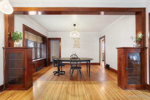 dining room with baseboards, light wood-style floors, and crown molding