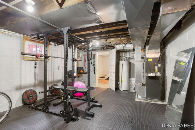 exercise area featuring concrete block wall, water heater, and heating unit