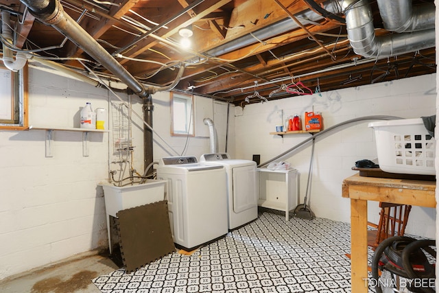 clothes washing area with laundry area, washer and clothes dryer, and a sink