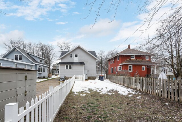 rear view of house featuring a fenced backyard and a residential view