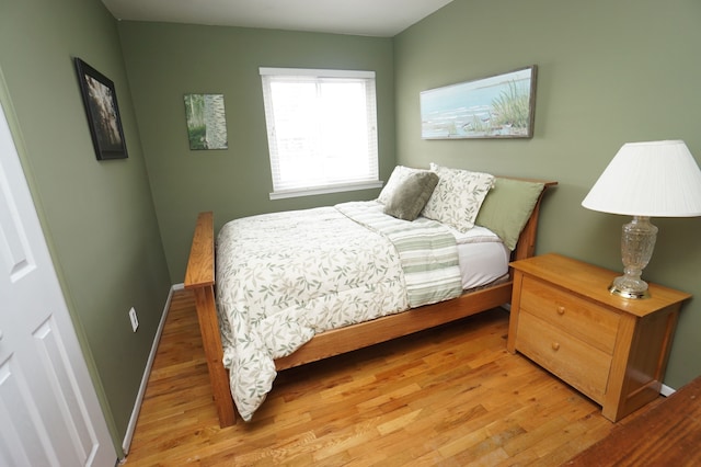 bedroom featuring baseboards and light wood finished floors