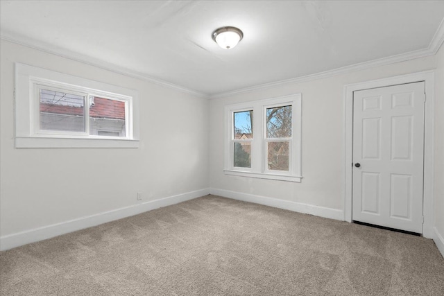 carpeted empty room with baseboards and crown molding