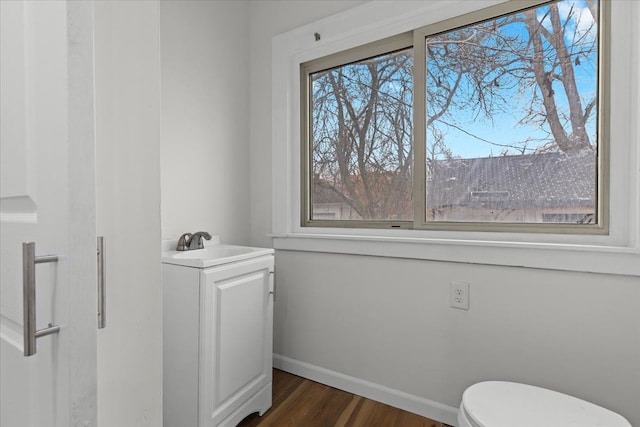 bathroom featuring vanity, wood finished floors, toilet, and baseboards