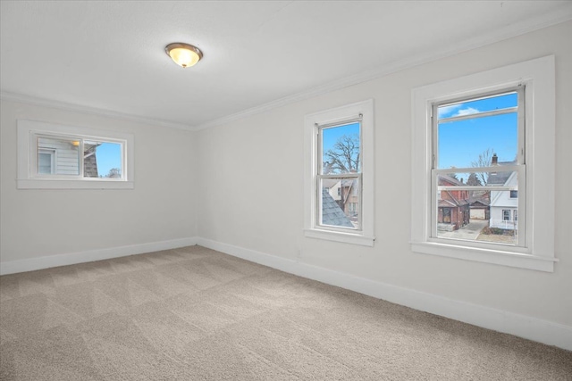 unfurnished room with baseboards, ornamental molding, and light colored carpet