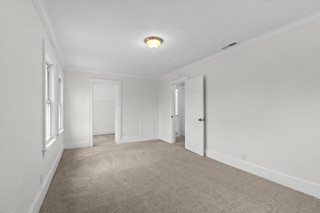 unfurnished bedroom featuring baseboards, carpet, visible vents, and crown molding