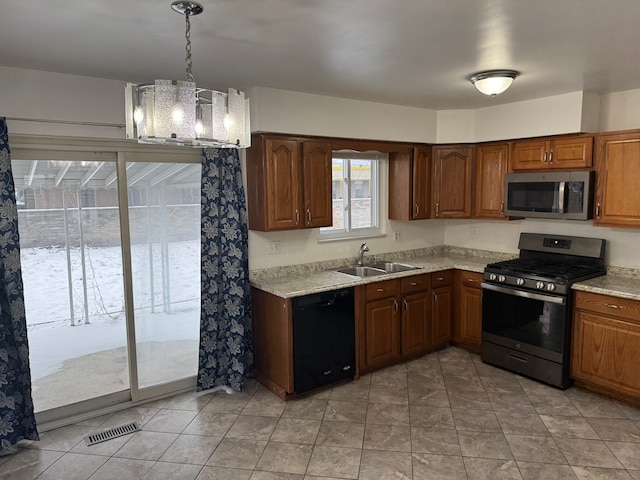 kitchen with hanging light fixtures, visible vents, stainless steel appliances, and a sink