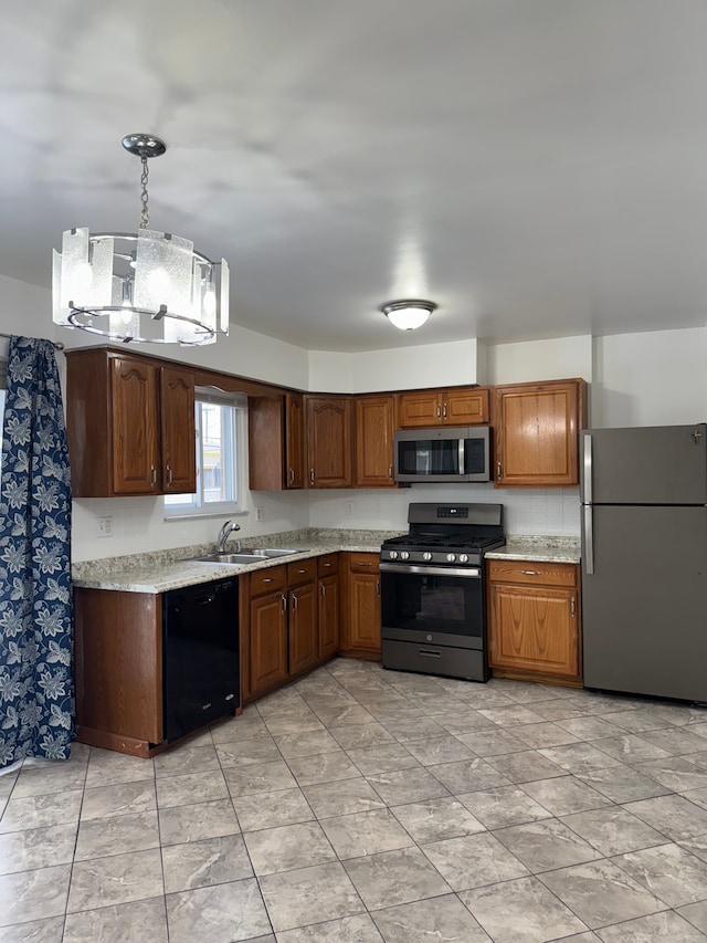 kitchen with stainless steel appliances, a sink, light countertops, and decorative light fixtures