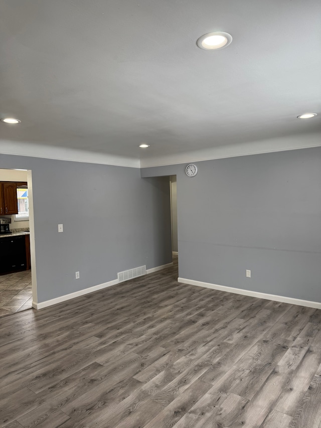 below grade area with recessed lighting, dark wood-style flooring, visible vents, and baseboards