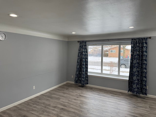 spare room with recessed lighting, wood finished floors, and baseboards