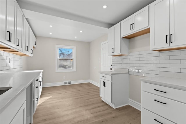 kitchen featuring visible vents, baseboards, light wood-type flooring, recessed lighting, and white cabinets