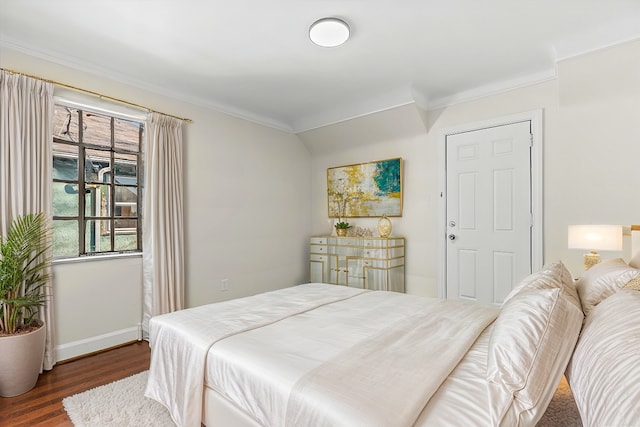 bedroom with baseboards, dark wood finished floors, and crown molding