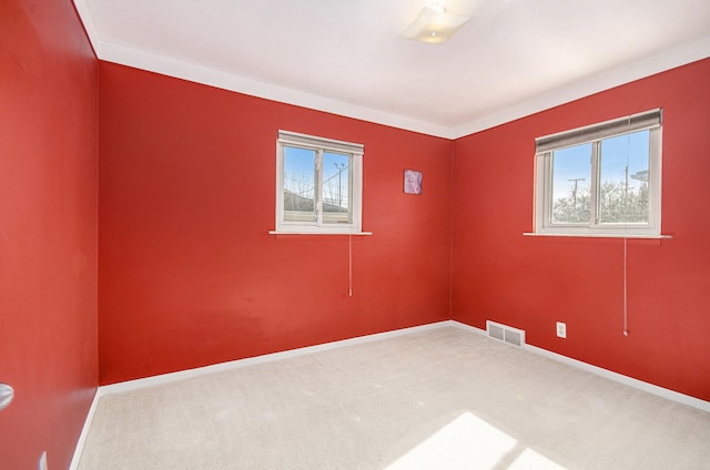 empty room with carpet floors, visible vents, and baseboards