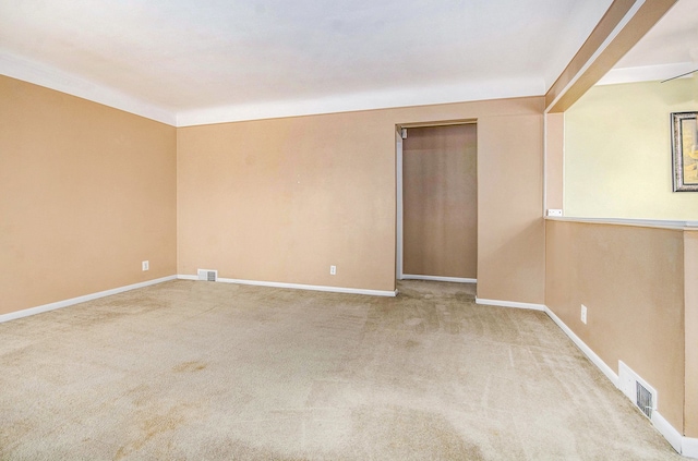 unfurnished room featuring carpet, visible vents, and baseboards