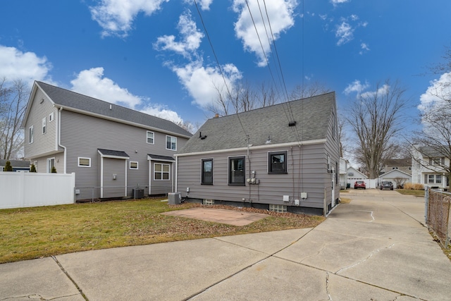 back of property featuring cooling unit, a lawn, and fence