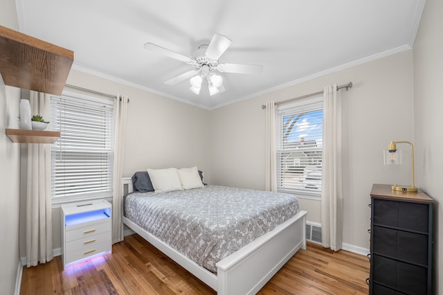 bedroom with ceiling fan, light wood-type flooring, and ornamental molding