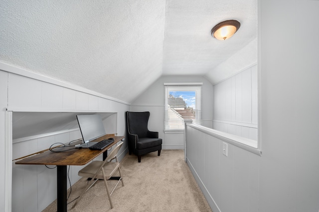 office space featuring lofted ceiling, a textured ceiling, and light carpet