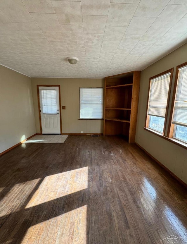 interior space with baseboards and wood finished floors