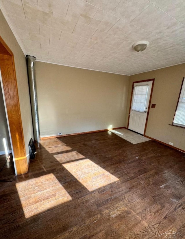 spare room featuring baseboards and wood finished floors