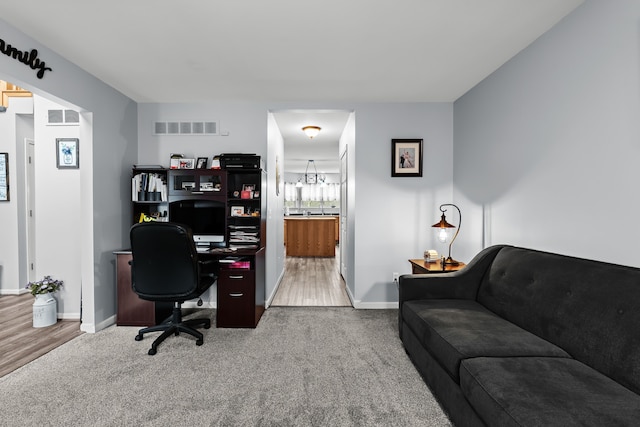 office space with visible vents, baseboards, carpet, and an inviting chandelier