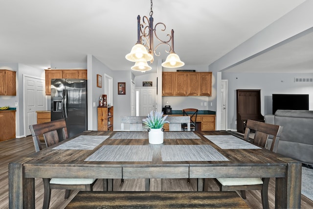 dining room with a notable chandelier, visible vents, baseboards, and dark wood-style flooring