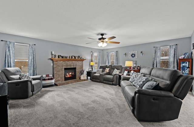 living area featuring carpet flooring, a fireplace, and ceiling fan