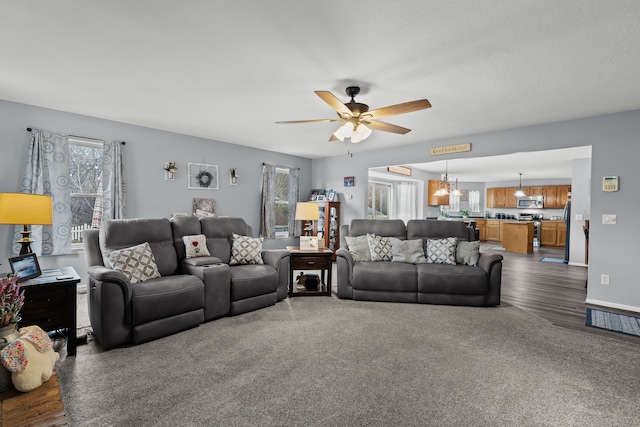 living room with baseboards and a ceiling fan