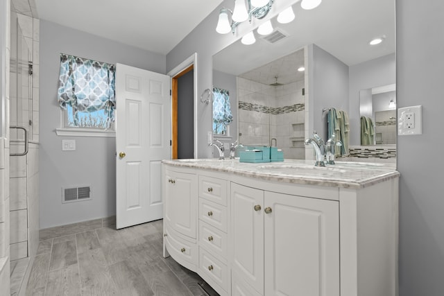 bathroom featuring a shower stall, visible vents, and a sink