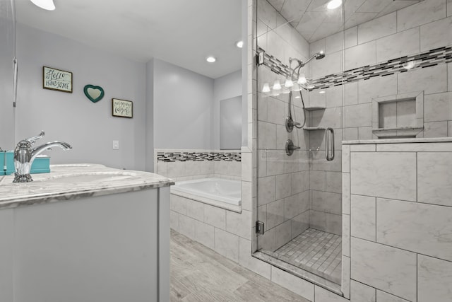 full bath with vanity, a bath, and a stall shower