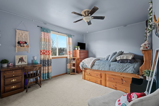 carpeted bedroom featuring baseboards and a ceiling fan