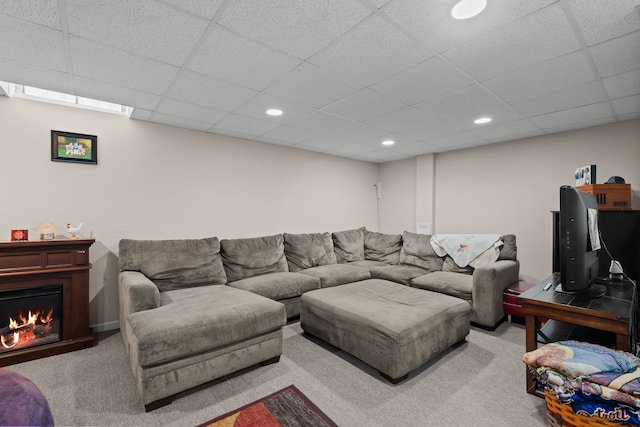 living area with recessed lighting, a drop ceiling, a lit fireplace, and carpet flooring