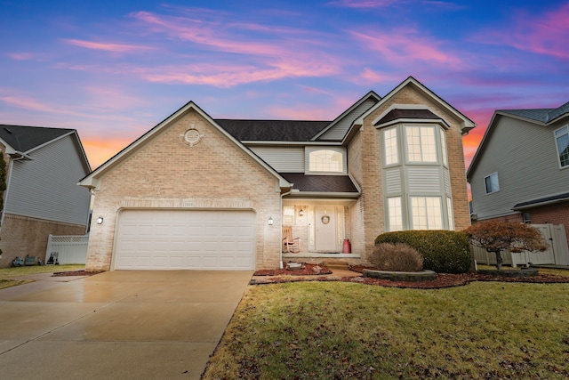 traditional-style house featuring fence, driveway, a front lawn, a garage, and brick siding