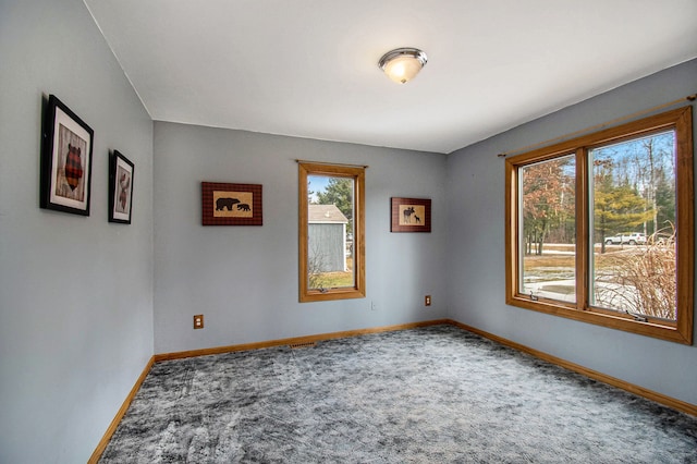 spare room featuring carpet floors and baseboards