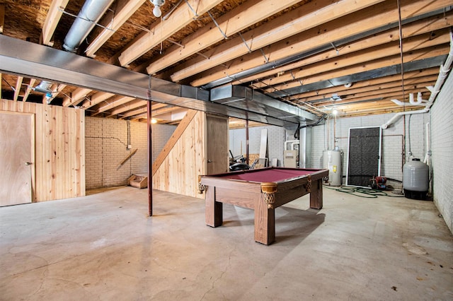 unfinished below grade area with water heater, brick wall, and pool table