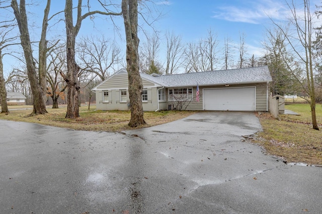 single story home with driveway and an attached garage