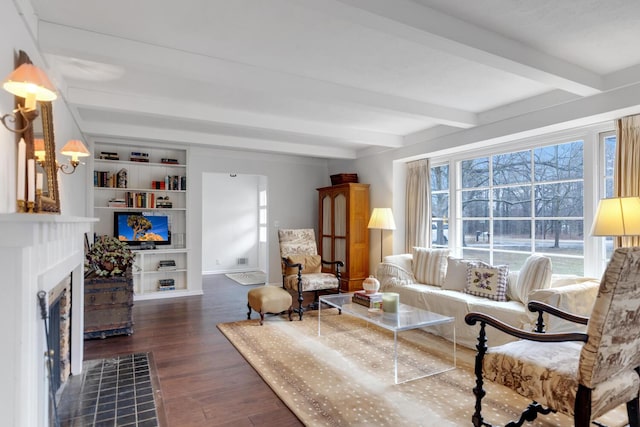 living room with baseboards, a fireplace with flush hearth, wood finished floors, built in shelves, and beam ceiling