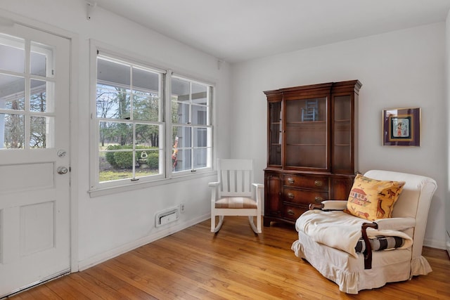 sitting room featuring baseboards and light wood finished floors