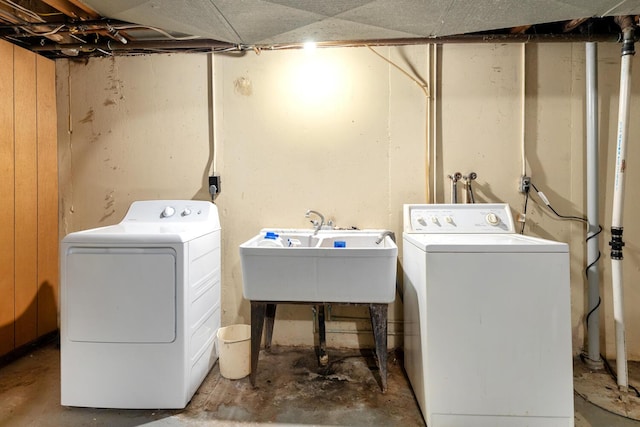 laundry area with laundry area, a sink, and washer and clothes dryer