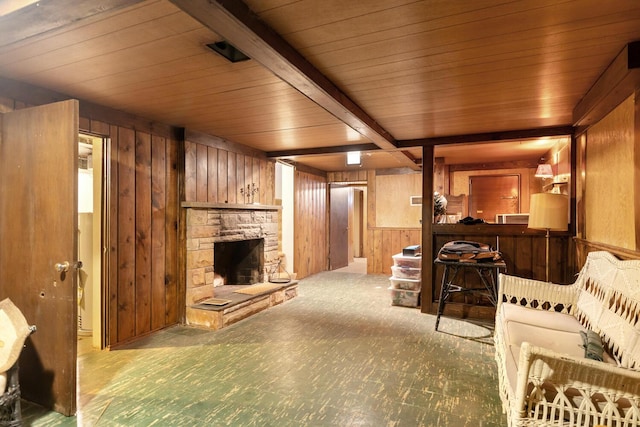 carpeted living room with wooden ceiling, wood walls, a fireplace, and beamed ceiling