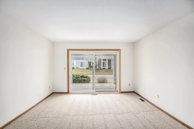 carpeted empty room with visible vents and baseboards