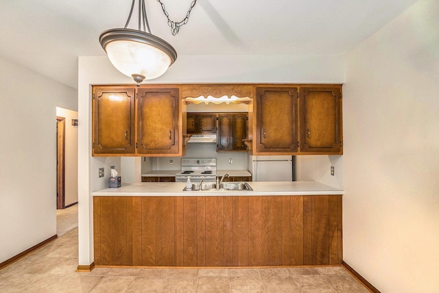 kitchen with brown cabinets, a sink, under cabinet range hood, and white electric range oven